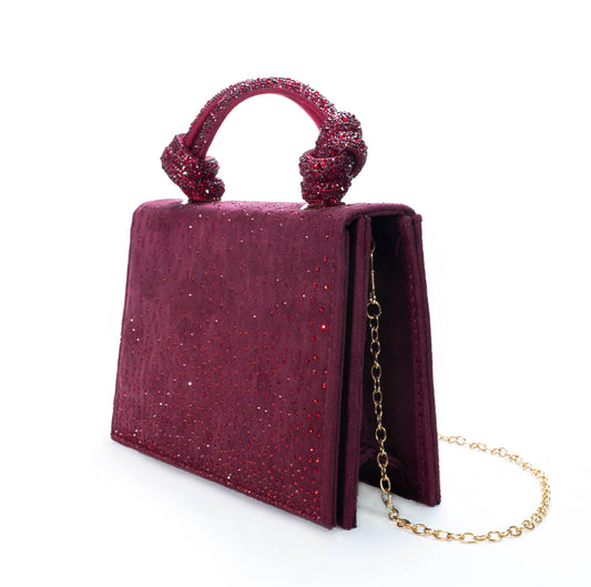Magenta handbag with gold chain on a white background