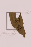 Brown fabric draped over a black frame on a light pink background with musical notes.