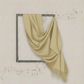 Beige fabric draped over a decorative frame on a light background
