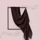 Black scarf draped over a black frame on a light pink background