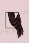 Black scarf draped over a black frame on a light pink background