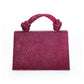 Magenta handbag with decorative handle on a white background