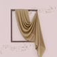 Green fabric draped over a framed picture on a light pink background