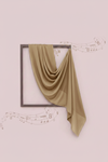 Green fabric draped over a framed picture on a light pink background