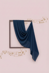 Navy blue fabric draped over a framed picture on a light pink background with decorative music notes.