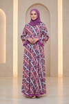 Woman wearing a patterned dress and purple hijab in a softly lit room.