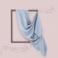 Blue fabric draped over a framed picture on a pink background