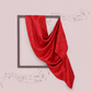 Red fabric draped over a rectangular frame on a light pink background with decorative elements.
