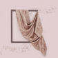 Decorative scarf with a pattern draped over a frame on a light pink background