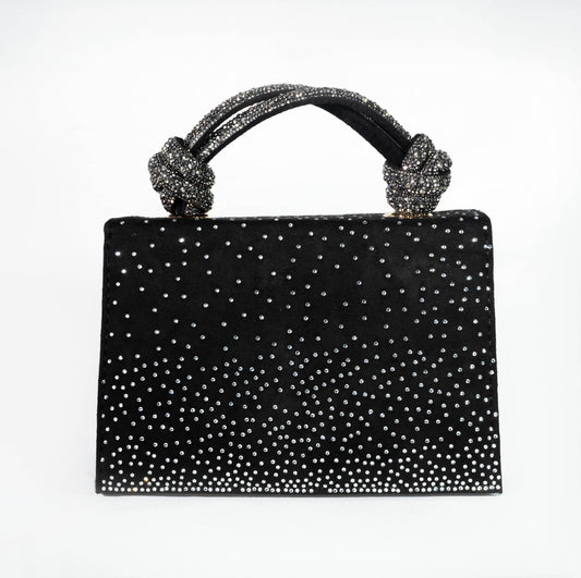 Black handbag with sparkling handle and studded design on a white background