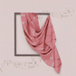 Pink patterned fabric draped over a framed picture on a light pink background