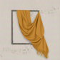 Mustard yellow scarf draped over a framed picture on a light gray wall.